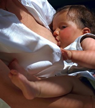 a baby contentedly on its mother's breast